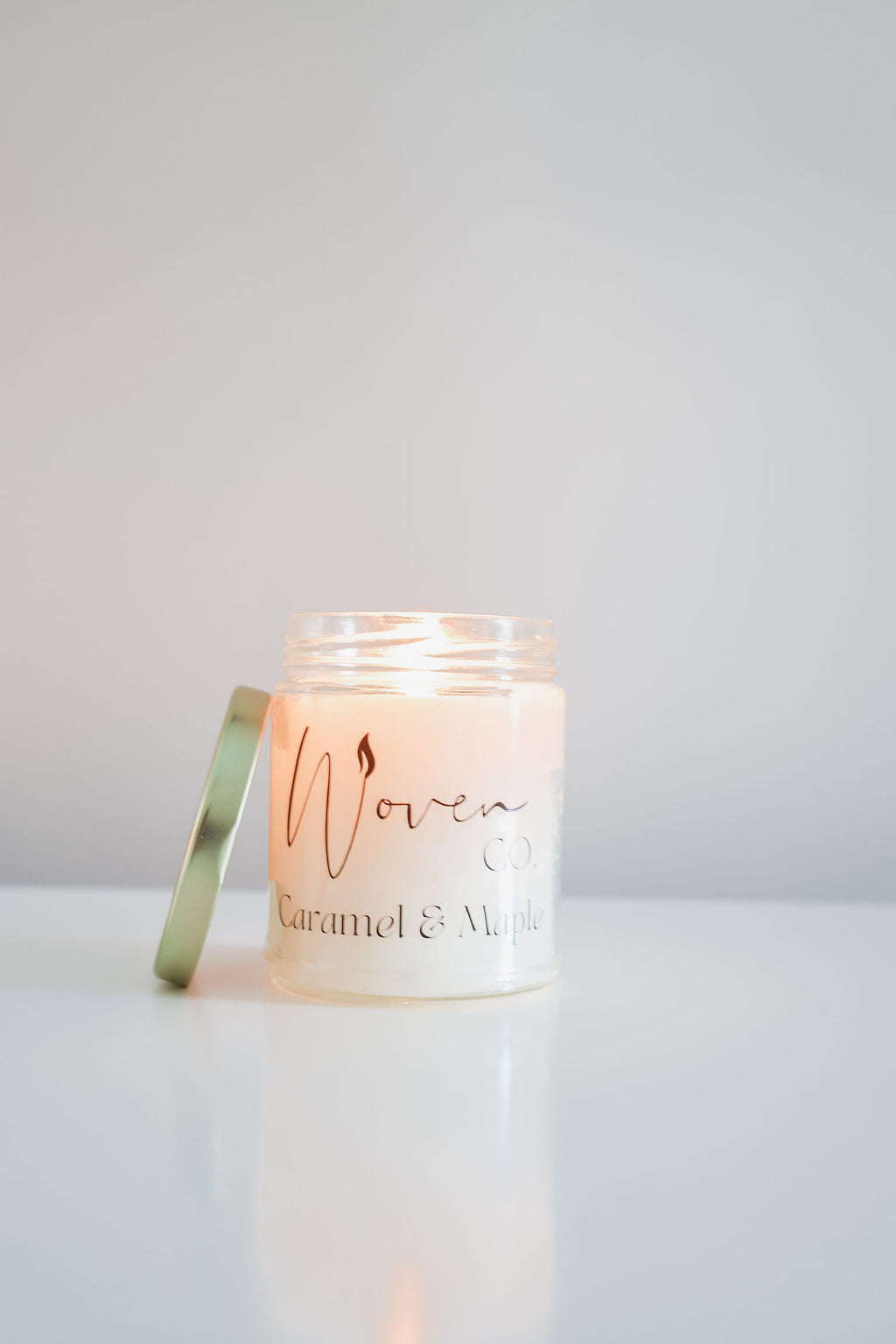 Candle in a glass jar with a label on a white background