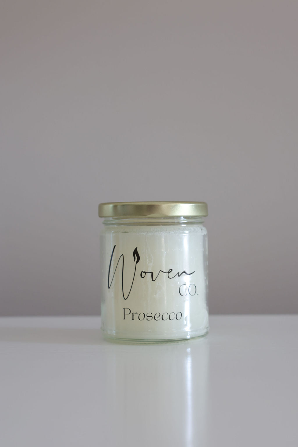 Jar of 'Woven Prosecco' on a white surface with a plain background